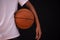 Closeup shot of young boy holding basketball under his arm
