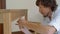 Closeup shot of a young man professional furniture assembler assembles a wooden table in a kitchen