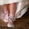 Closeup shot of a young person in pink high-tops on the ground under the lights