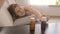 Closeup shot of young sick woman reaching for pills in bottle from bedside table