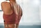 Closeup, shoulder muscle and woman at a gym for training, exercise and cardio against a blurred background. Zoom, back