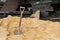 Closeup shovel embedded in sand construction concept.