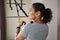 Closeup side portrait of a young woman performing functional training with fitness straps