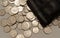 Closeup of silver Canadian Coins spread out and spilling from leather pouch in a corner pattern