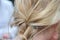 Closeup of a simple braided blonde hair under the lights with a blurry background