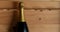 Closeup of a single champagne bottle in a wood crate. Horizontal with copy space. Bottle has no label