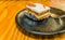 Closeup of single piece of carrot cake decorated with a pecan