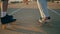 Closeup skaters legs riding longboards asphalt road. Unknown pair moving speedy