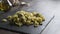 Closeup of a slate plate with steaming orecchiette with broccoli, typical Apulian recipe, in backlight on dark wooden table with