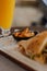 Closeup of a sliced burger and a glass of orange juice in a restaurant, blurred background