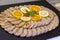 Closeup of sliced stuffed chicken roulade on a plate with orange and lemon slices