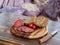 Closeup sliced unleavened bread and vegetarian sausage on round cutting wooden board on wooden table.