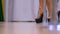 Closeup slim legs in shiny strip shoes dance near pole
