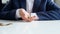 Closeup slow motion footage of businessman sitting behind office desk and tossing coins on hand. Concept of financial