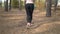 Closeup slow motion shot of woman in leggings running at forest
