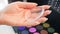 Closeup slow motion video of female makeup artist holding transparent silicone gel applicator for applying makeup on