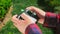 Closeup slow motion video of teenage boy holding remote control and flying drone at park