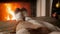 Closeup slow motion video of woman warming feet at fireplace and drinking hot tea