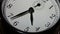 Closeup on slowly rotating clock face with fast moving clock hands - time running out
