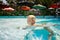 closeup small blonde girl swims in shallow hotel swimming pool