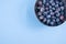 Closeup of a small bowl of blueberry on the aesthetic blue background.