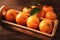 Closeup of a small crate of Mandarin Oranges on a rustic wood table with warm side light