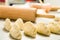 Closeup small delicious empanadas lined up before baking, rolling pin background