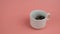 Closeup of a small funny miniature jungar hamster in a white cup.