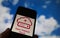 Closeup of smartphone with logo lettering of cloud computing provider service open telekom, blurred sky and cloud background