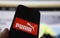 Closeup of smartphone screen with logo lettering of puma sports company, blurred website background