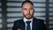 Closeup smiling business man in suit tie posing with crossed hands at night office jalousie shadow