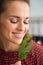 Closeup of smiling woman holding up and smelling fresh dill