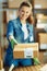 Closeup on smiling woman in jeans in office giving parcel