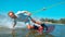 CLOSEUP Smiling young Caucasian surfer wakeboarding, splashing water at camera