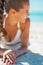 Closeup on smiling young woman in swimsuit laying on beach