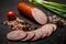 Closeup smoked ham sausage with green onions and tomato