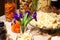 Closeup snacks, dried fruits and nuts in glass bowl, flowers irises in vase, plate with pieces with parmesan cheese. Concept