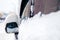 Closeup snow covered window and rearview mirror of grey minibus car. Concept snowy weather, snowfall, bad northern weather