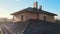 Closeup snow guard for safety in winter on house roof top covered with ceramic shingles. Tiled covering of building