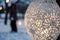 closeup of snow lantern with intricate patterns, person in background