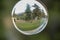 Closeup of the soap bubble reflecting the summer park.