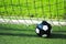 Closeup of a soccer ball in the goal net on a green lawn