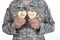 Closeup of a soldier holding two Heart Shaped Valentines Day cookies with the words Be Mine and XOXO written in red icing