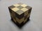 Closeup of a solved wooden puzzle cube on a gray surface