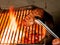 Closeup of someone turning a tasty steak cooking on a fire