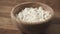 Closeup sour cream pour on cottage cheese in wood bowl