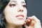Closeup specialist in beauty salon gets lipstick, lip gloss, make-up.