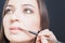 Closeup specialist in beauty salon gets lipstick, lip gloss, make-up.