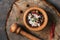 Closeup spices peppercorn, salt, herbs in a wooden mortar on a stump board, overhead view