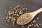 Closeup Spoon of Dried Coriander Seeds on Black Wooden Background